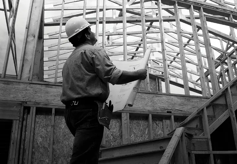 Man looking at blueprints on job-site