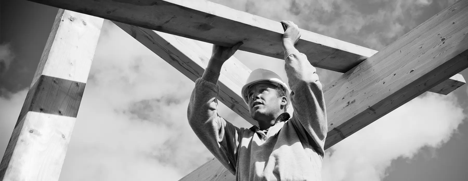 Construction worker holding beam overhead