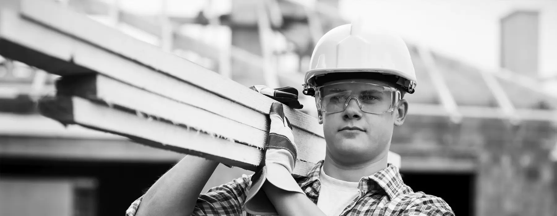 Construction worker carrying lumber